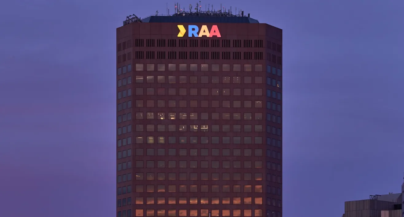 RAA tower with illuminated rooftop signage at dusk